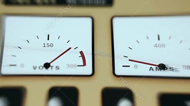 Analog gauges measuring electrical parameters in industrial setting