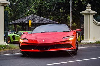 Red Ferrari SF90 stradale Plug-in Hybrid Electric Vehicle PHEV hypercar driving on the wet road after rain