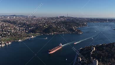 Cargo ship sailing through bosphorus strait aerial view