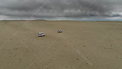 Offroad vehicles cross Gobi Desert dunes in Mongolia through remote sand country, desert convoy, sand dunes, dune crossing