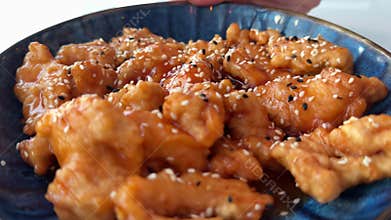 Chicken wings in sweet and sour sauce with sesame