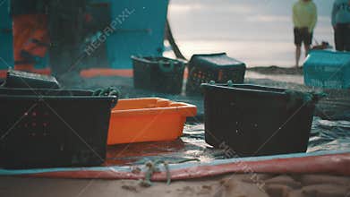 Fishermen unloading fresh catch in plastic baskets