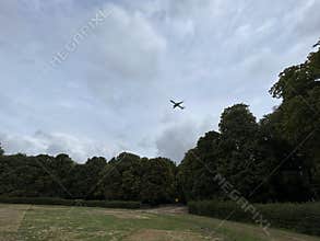 Commercial Airplane Flying Over Amsterdam Forest Under Cloudy Sky Netherlands