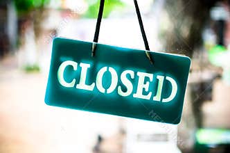 Close sign hanging on glass of shop