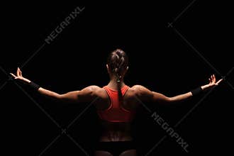 Athletic young woman showing muscles of the back