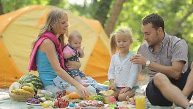 Cheerful family having picnic with fruits