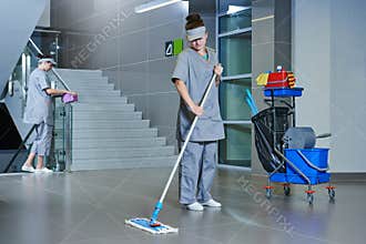 Worker cleaning floor with machine