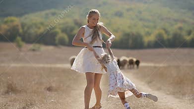 Beautiful mother in light dress holding her little