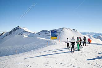 Skiers look at information board on mountain's top