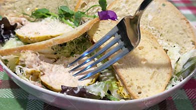 Caesar salad with croutons and grilled chicken closeup fork picking piece salad bowl