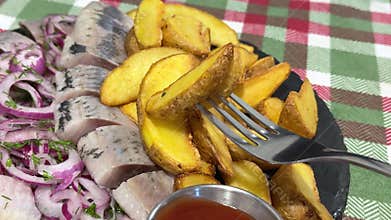 Fork lifting rustic potatoes herring nearby checkered tablecloth meal food Fork lifting rustic potatoes examining