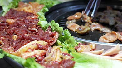 Korean BBQ Feast in Seoul: Marinated Beef and Pork Sizzling on Hot Plate with Fresh Lettuce Wraps
