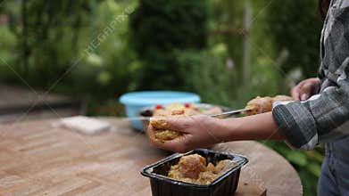 Person preparing marinated chicken skewers for barbecue