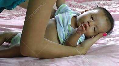 Young mother dressing her son