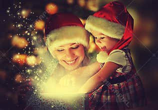 Christmas magic gift box and a happy family mother and daughter baby girl