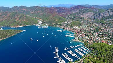 Aerial drone view of Gocek marina and forested bay with boats homes and vivid blue sea, yachts, coastal town, mugla, turkiye