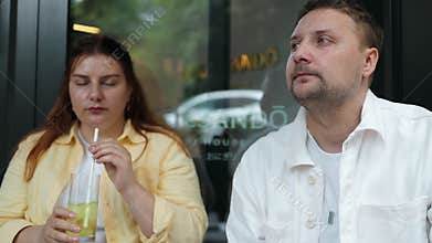 Young drinking refreshing lemonade from glasses in an outdoor cafe