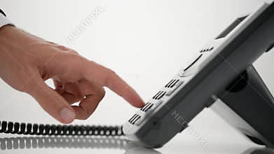 Male hand dialing telephone number and picking up a handset
