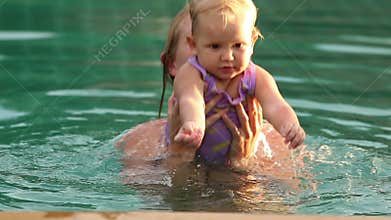 Mother and douther swim in the pool