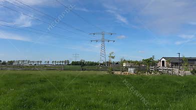 High Voltage Electricity Pylons and Power Lines Across Rural Landscape Near