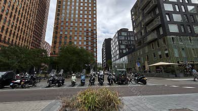 Urban streetscape with parked scooters and modern highrise buildings under