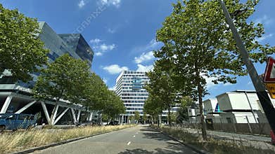 Modern office district street with glass high rises, tree lined boulevard, blue