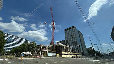 Modern office district with crane above road and tram lines in Amsterdam