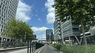 Modern office building and tram at urban street with blue sky and
