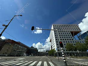 Modern city intersection with elevated office building, traffic lights