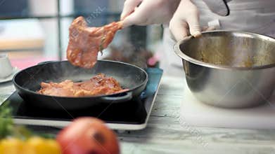 Frying pan with marinated meat.