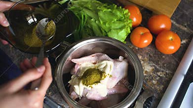 Closeup of woman cook hands put spices into pan with chiken wings in kitchen at home