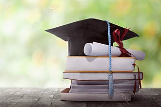 Graduation hat with degree paper on a stack of book