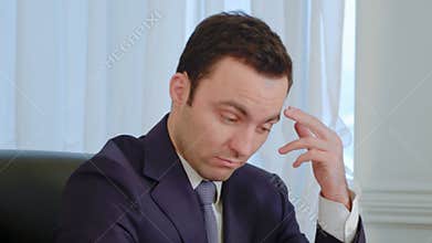 Tired businessman concentrated on work and yawning in the office