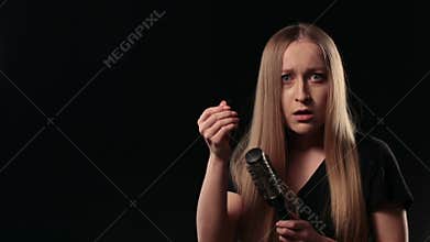 Shocked woman looking at hairbrush. Hair loss.