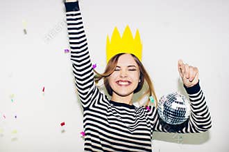 Birthday party, new year carnival. Young smiling woman on white background celebrating brightful event, wears stripped