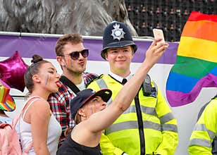 People Taking Selfie With Police Officer At Pride Parade.