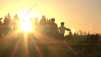 Silhouette of kids running away at sunset