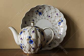 Porcelain sugar bowl, cup, milk, dish with golden pattern and blue flowers.