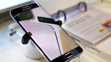 People looking price tag with display Samsung Galaxy Note 7 cellphone