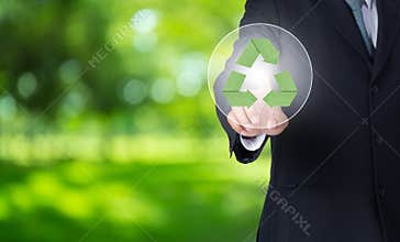 business man finger pointing at paper green recycle symbol with nature background.