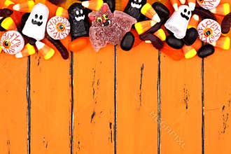 Halloween candy top border over old orange wood
