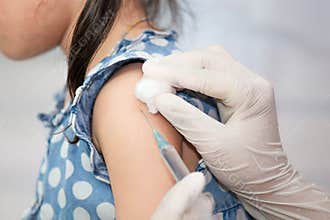 Doctor injecting vaccination in arm of asian little child girl