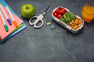 School breakfast on desk with books and pen on board background