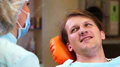 Dentist talking to man patient after examination