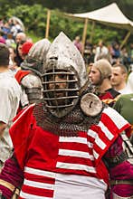 Participant of the festival in knight armor prepares to fights.