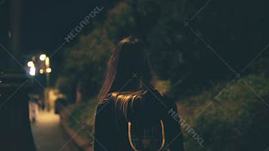 Young attractive woman walking late at night alone in Rome, Italy. Girl goes through the city centre near the Colosseum.