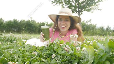 Young woman have fun in the park and drink green smoothies