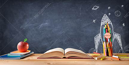 Start School Concept - Supplies On Desk And Rocket Drawn