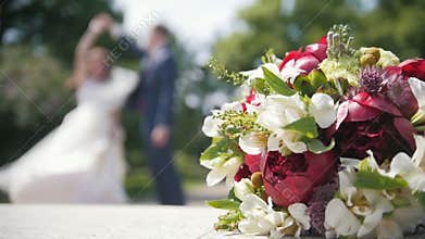 Bride and groom dancing in front of wedding bouquet, slow-motion