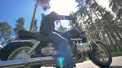 A low view on a man sitting on his bike. Motorcyclist.